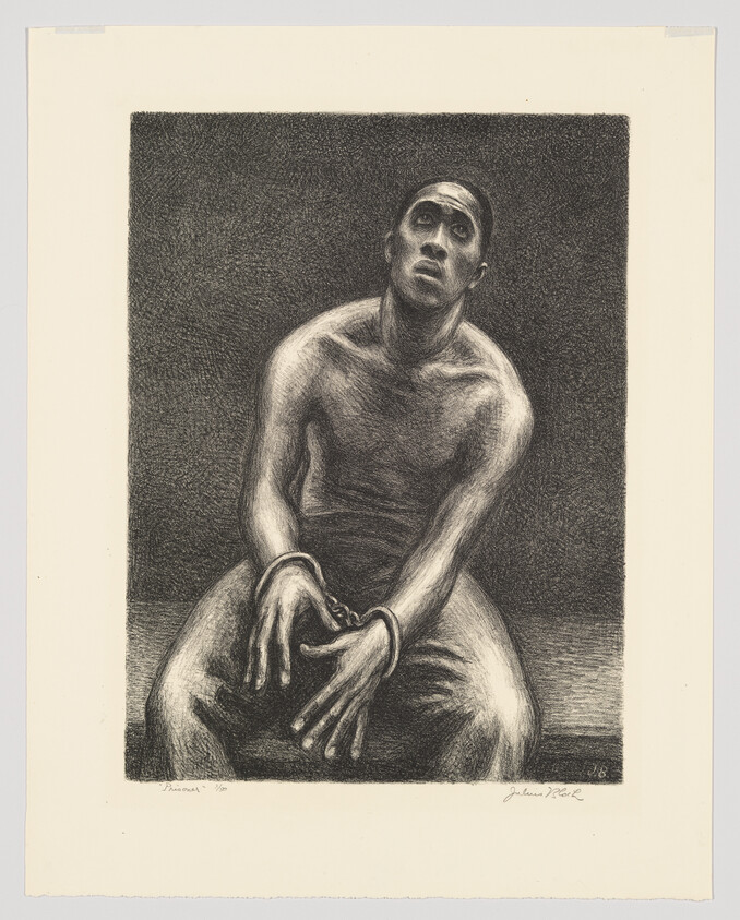 A shirtless man sits with shackled hands, looking upward with a pained expression.