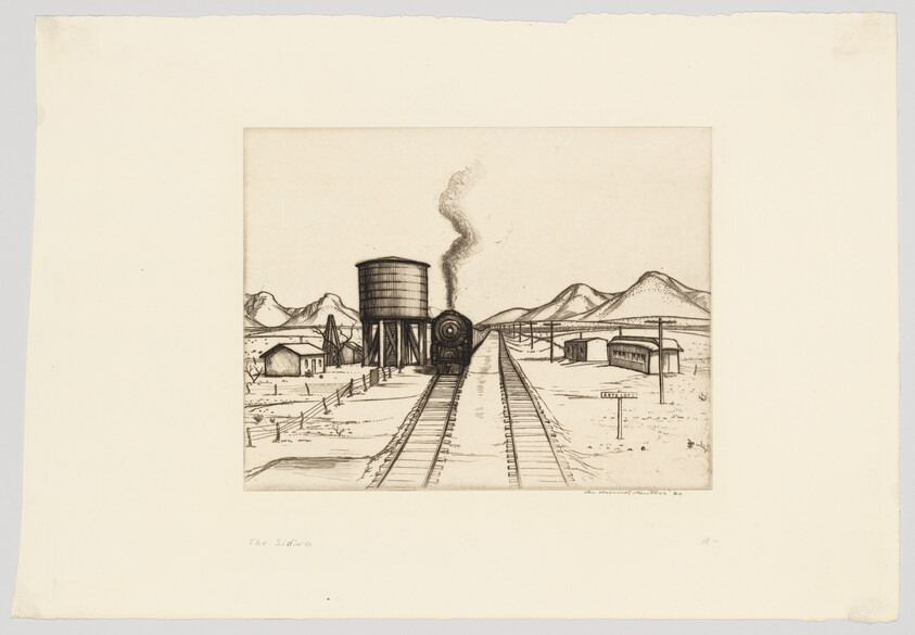 Steam locomotive sits at a desert water tower beside railroad tracks with distant mountains.