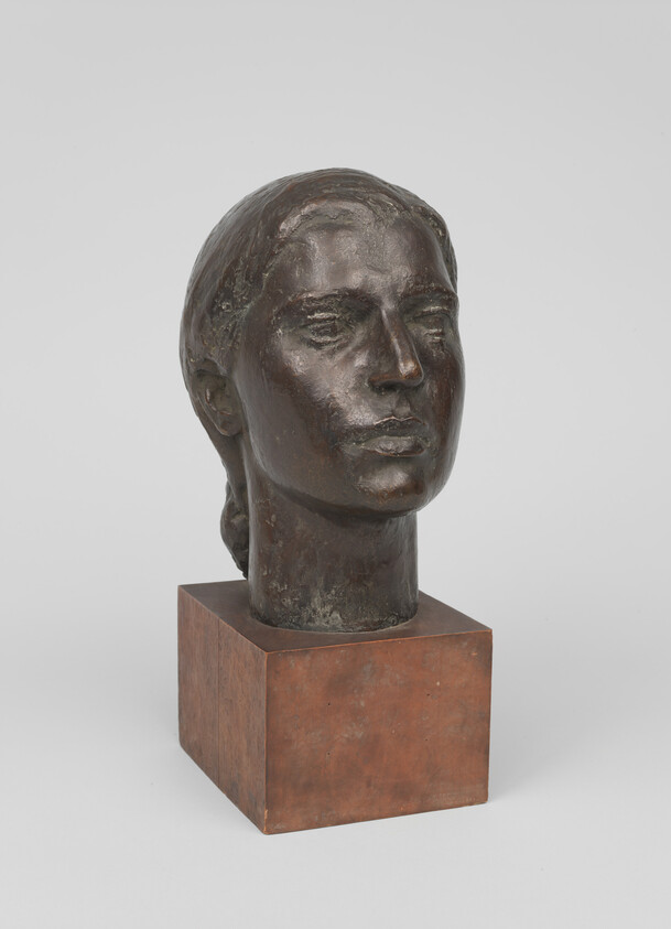 Bronze bust of a woman's head with hair pulled back on a square pedestal.
