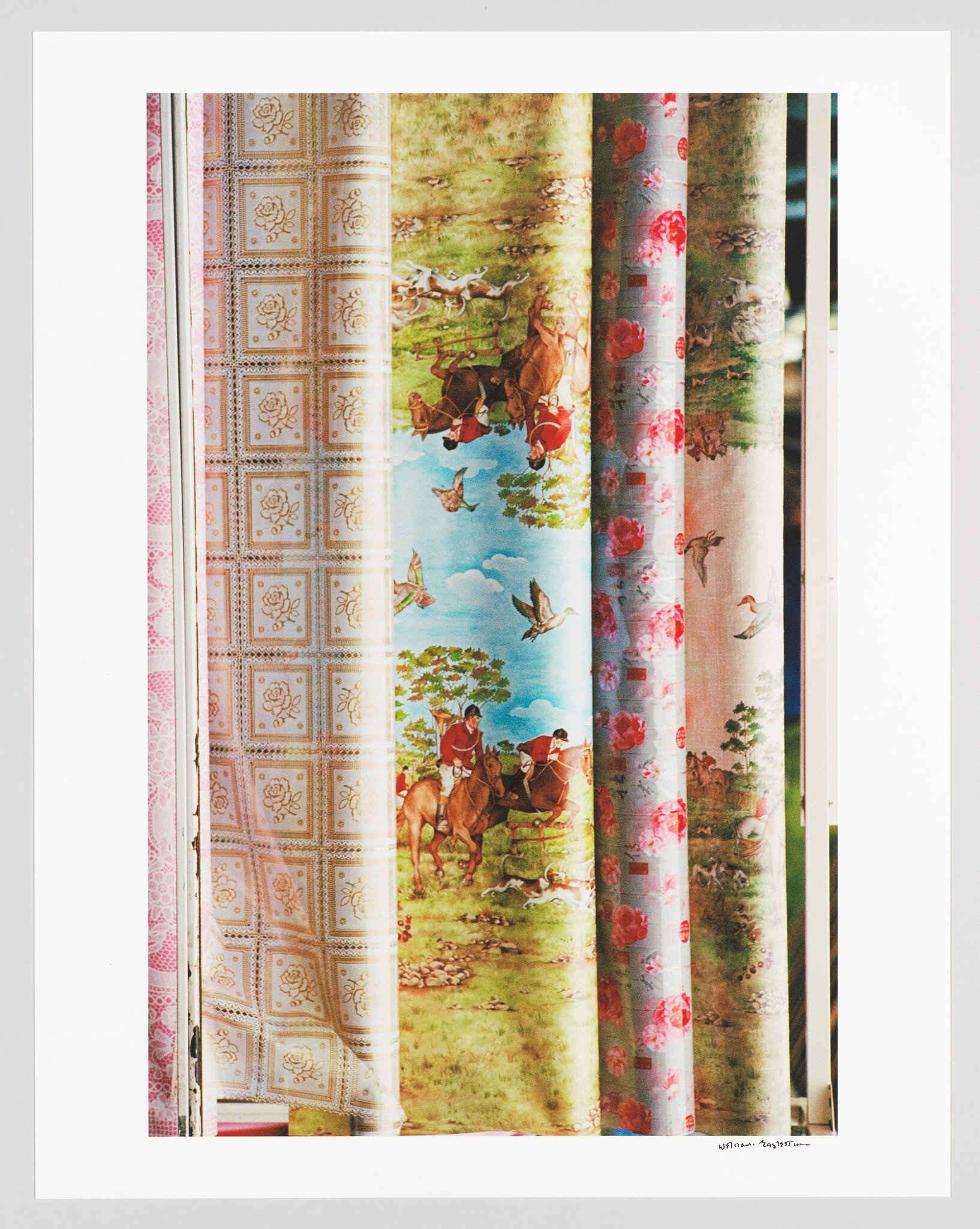 A collection of vertically aligned fabric samples with various patterns including geometric designs, pastoral scenes with horses, and floral motifs, displayed against a white background.