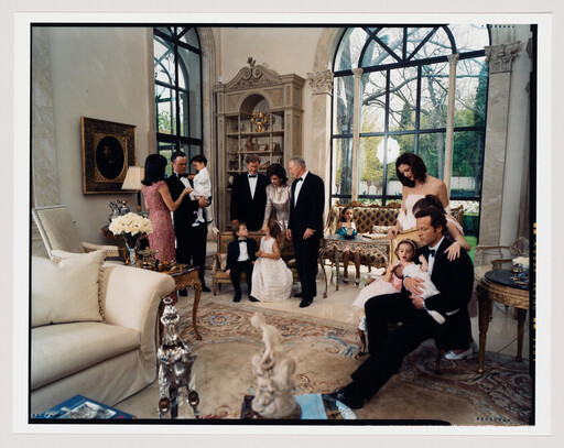 A multigenerational family in formal attire gathers in an elegant living room, adults and children interacting.