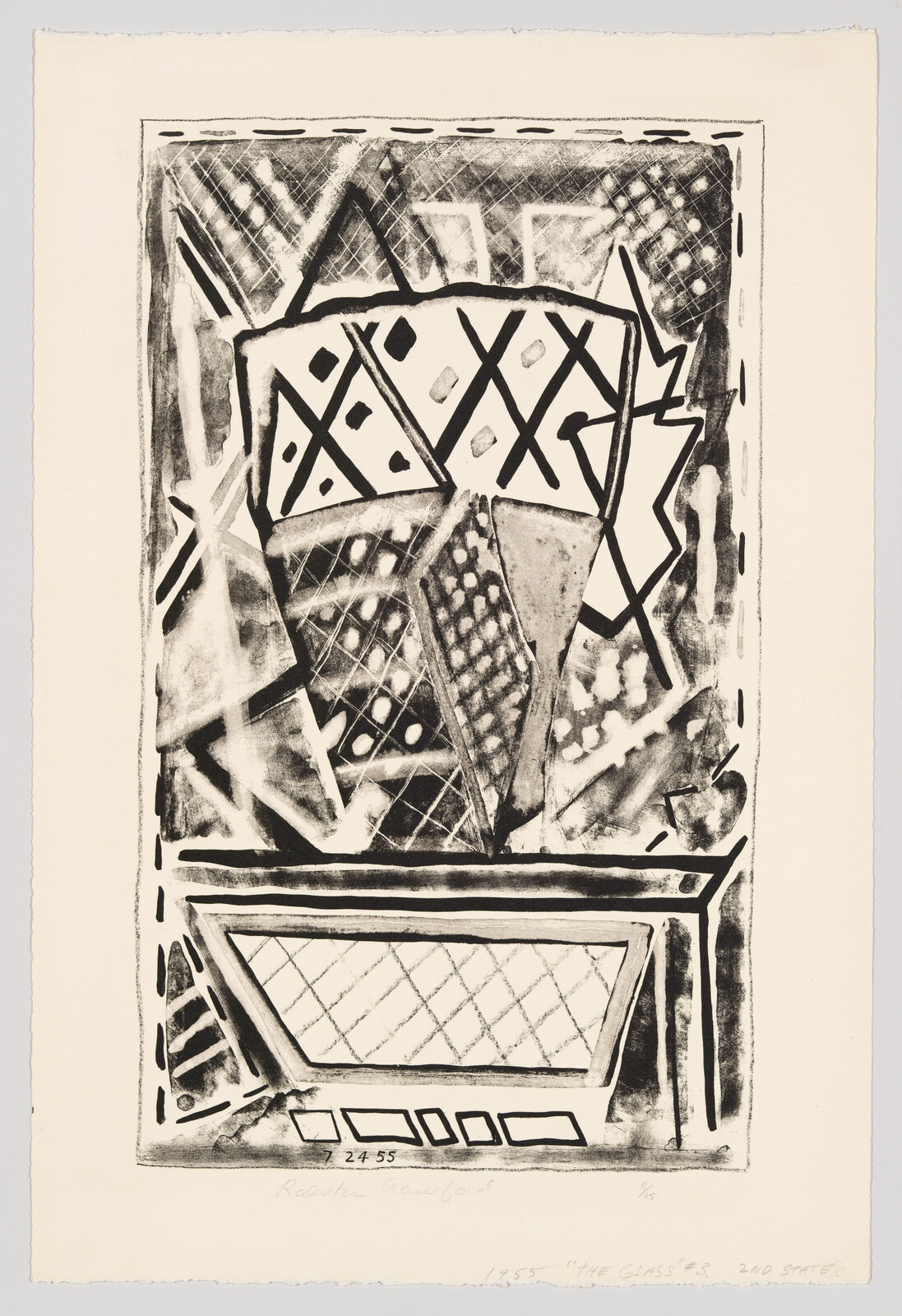 Abstract black-and-white geometric vase with diamond patterns sitting on a low table.