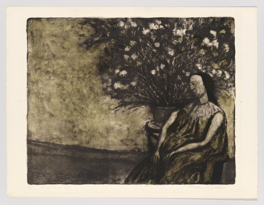 A seated woman in a dark dress sits quietly beside a large vase of flowers.