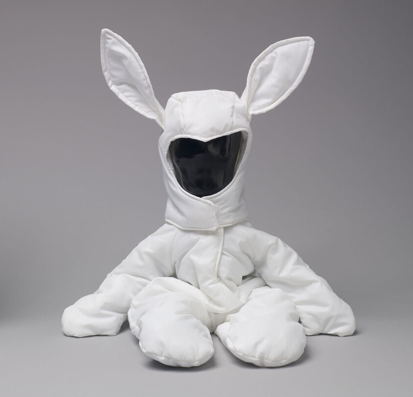 A white padded bunny costume with large ears displayed on a black-faced mannequin.