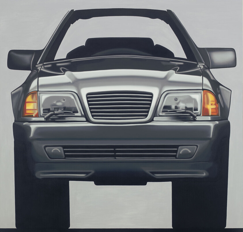 Front view of a dark convertible car with headlights and turn signals illuminated.