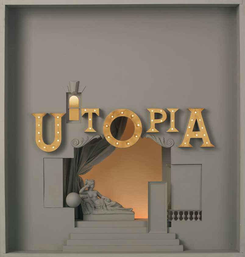 A lit UTOPIA sign above a draped stage with a reclining classical statue in an alcove.