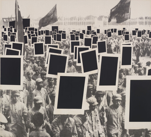 Crowd of uniformed marchers carrying blank black placards and flags in a large demonstration.