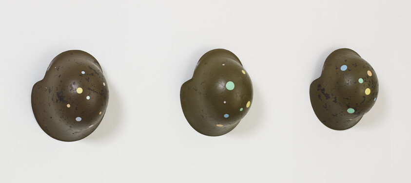 Three dark speckled chocolate eggs arranged in a row on a white background.