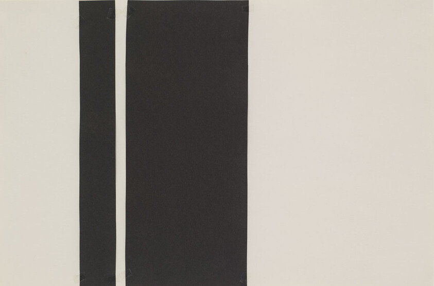 Two vertical black strips taped to a pale wall, one narrow and one wide, on the left side.