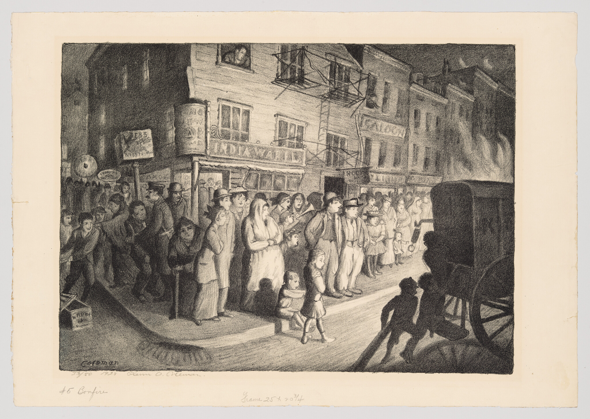 A crowd of men, women, and children stand on a city street watching a burning wagon bonfire.