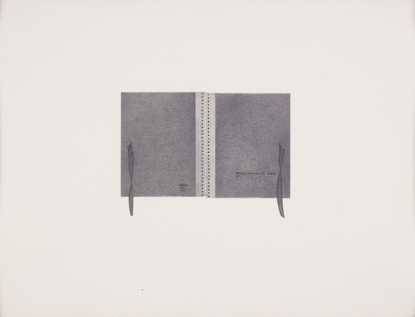 A grey sketchbook with a white binding and grey ribbon is folded open