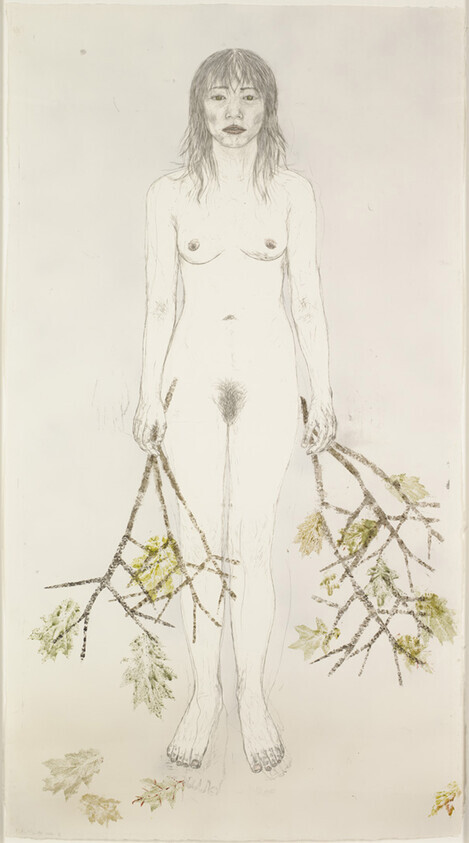A nude woman stands facing forward holding leafy tree branches in both hands.