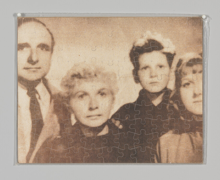 Four people in a sepia family portrait printed on an assembled jigsaw puzzle.