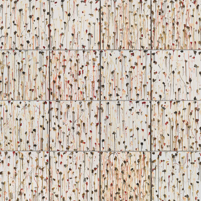A tiled wall covered in thin vertical paint drips and small colored splatters.