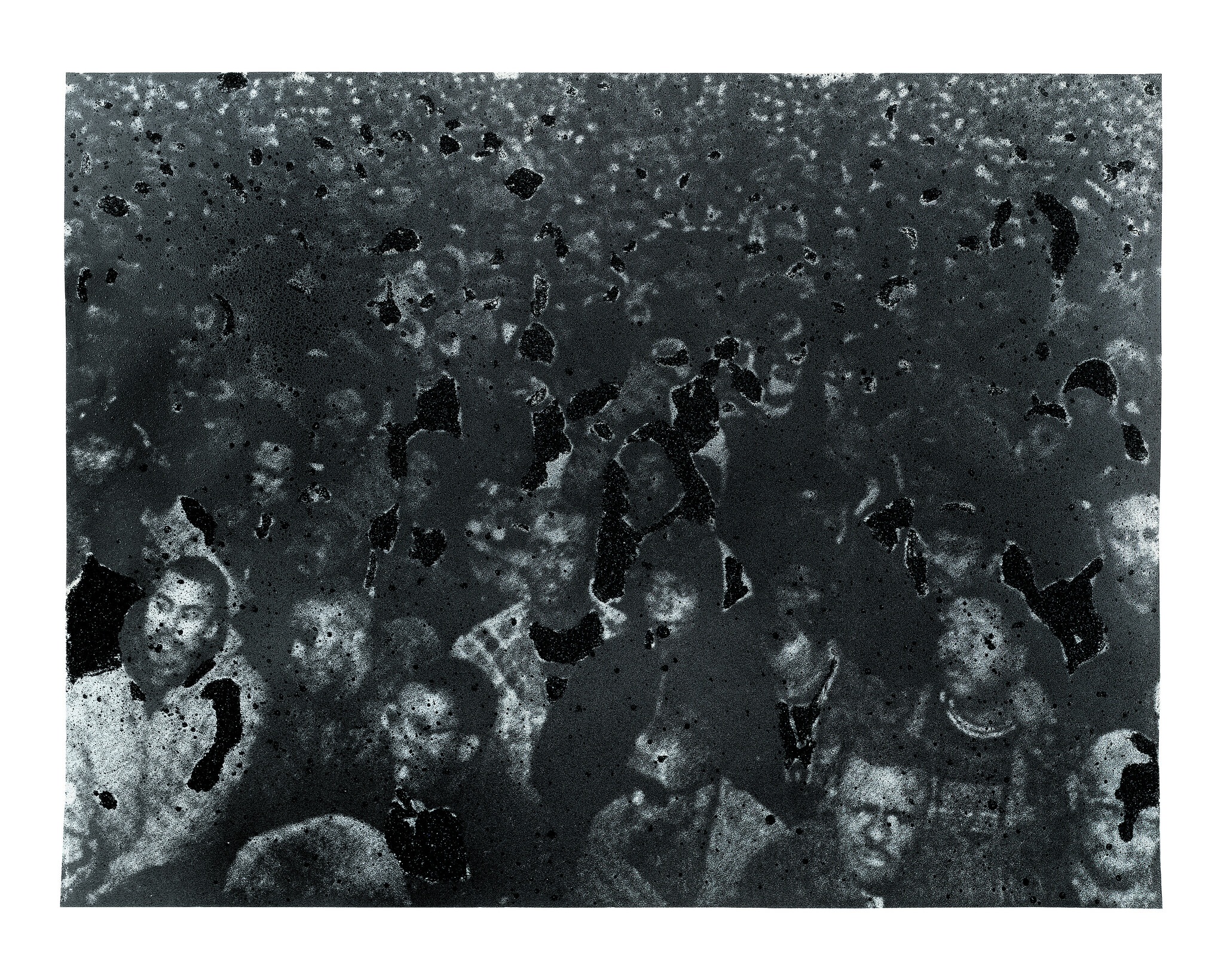 A large crowd of people looking forward, with dark spots and damage obscuring parts of the image.