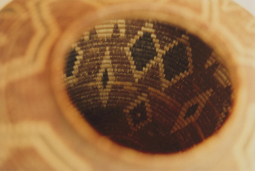 A close-up view of a woven basket interior with dark diamond-shaped geometric patterns.