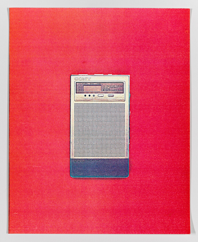 Vintage Sony portable radio on a red background.