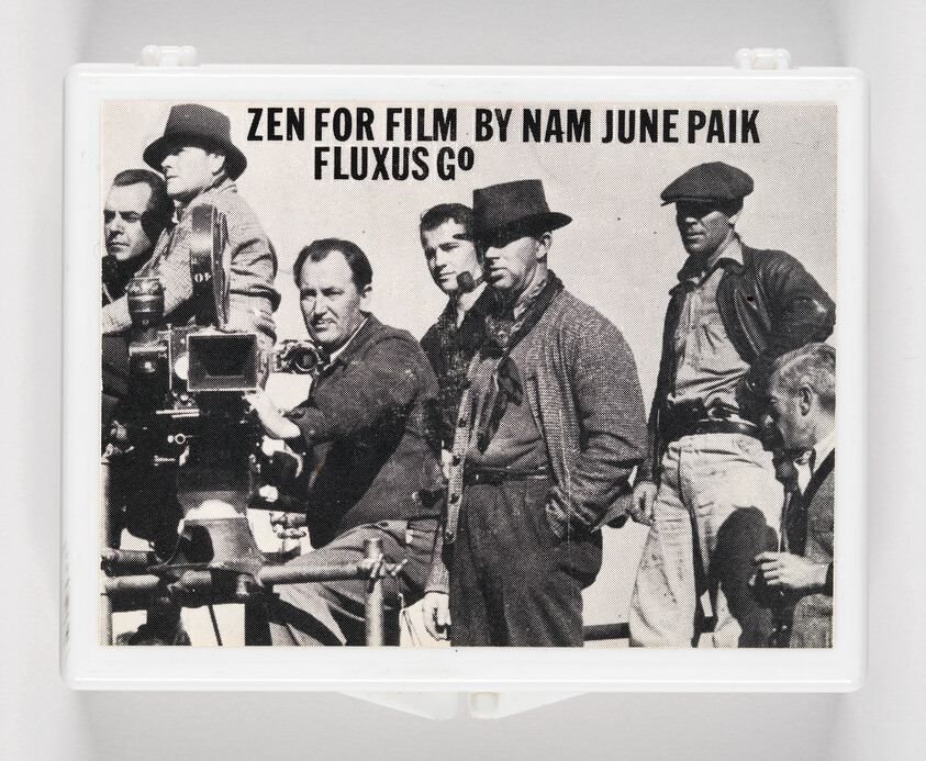 A black and white photo of a group of men with vintage filming equipment, featured on a DVD case with the text "ZEN FOR FILM BY NAM JUNE PAIK FLUXUS GO".