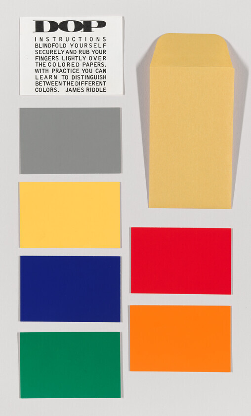 Eight colored cards and an envelope arranged in a grid for a color-matching test.