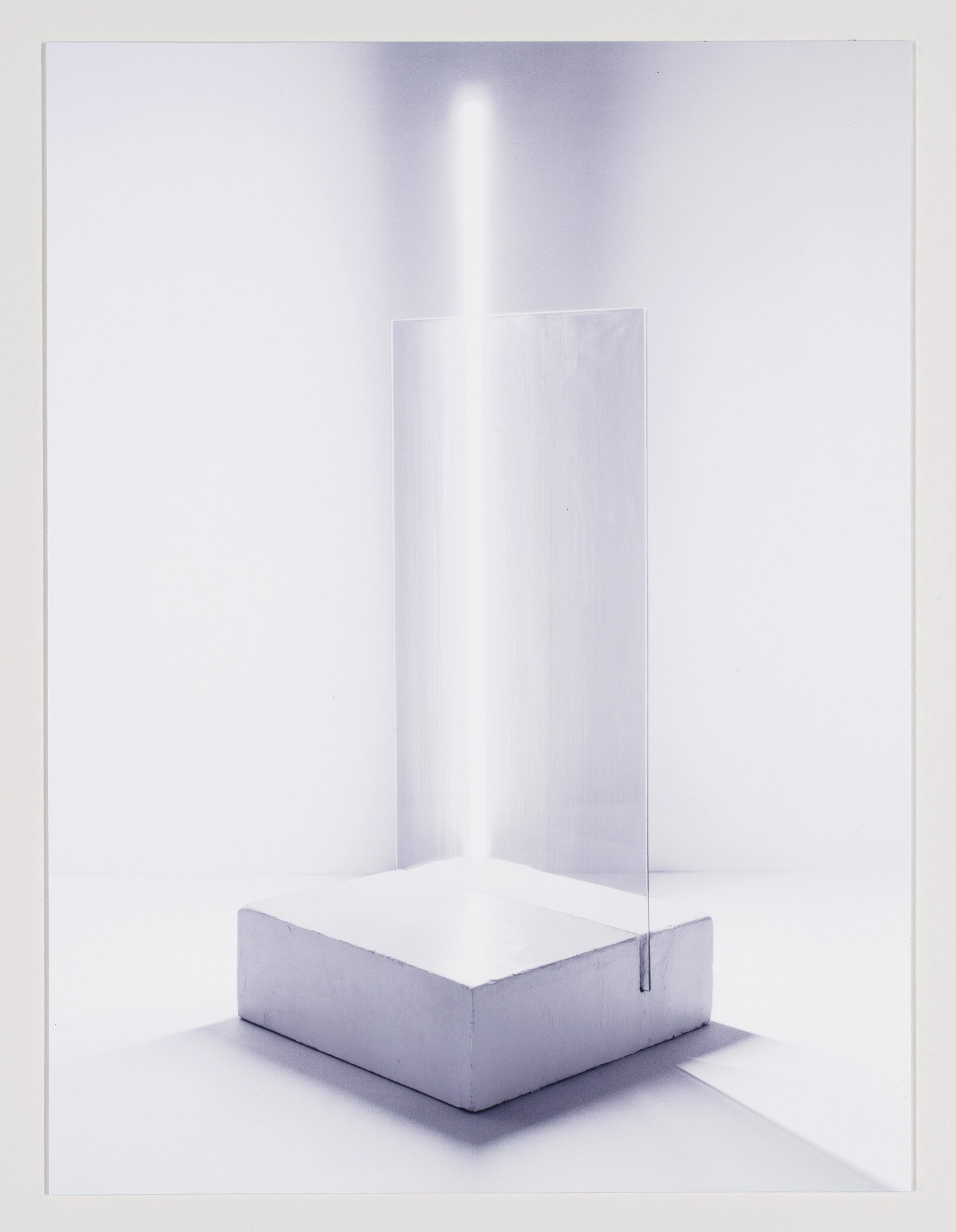 A rectangular white block supports a vertical translucent panel with a bright beam of light.