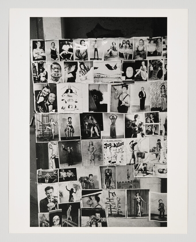 A wall covered with a collage of black-and-white portrait photographs arranged in rows and columns.