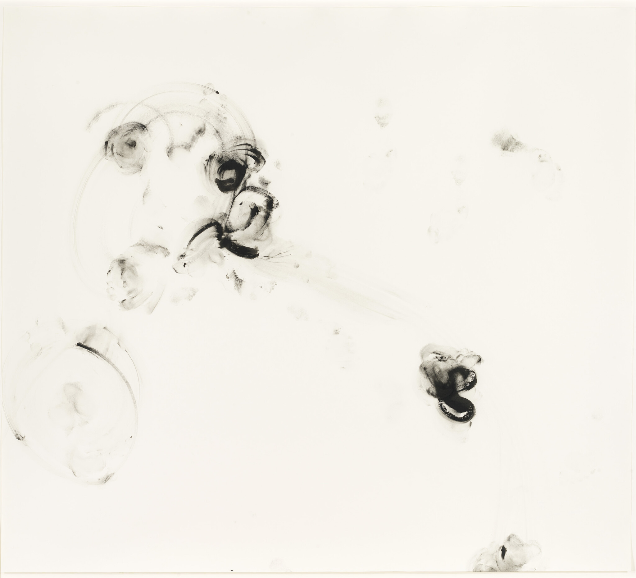 Light black ink smudges and swirls are scattered across a plain white background, forming an abstract pattern.