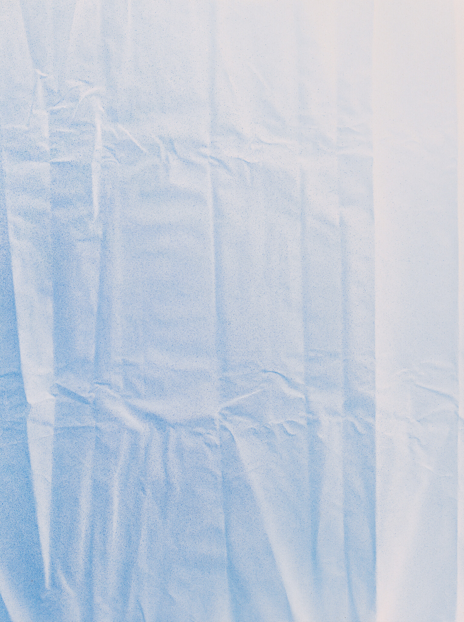 A pale blue plastic sheet with vertical creases and wrinkled folds covering the frame.
