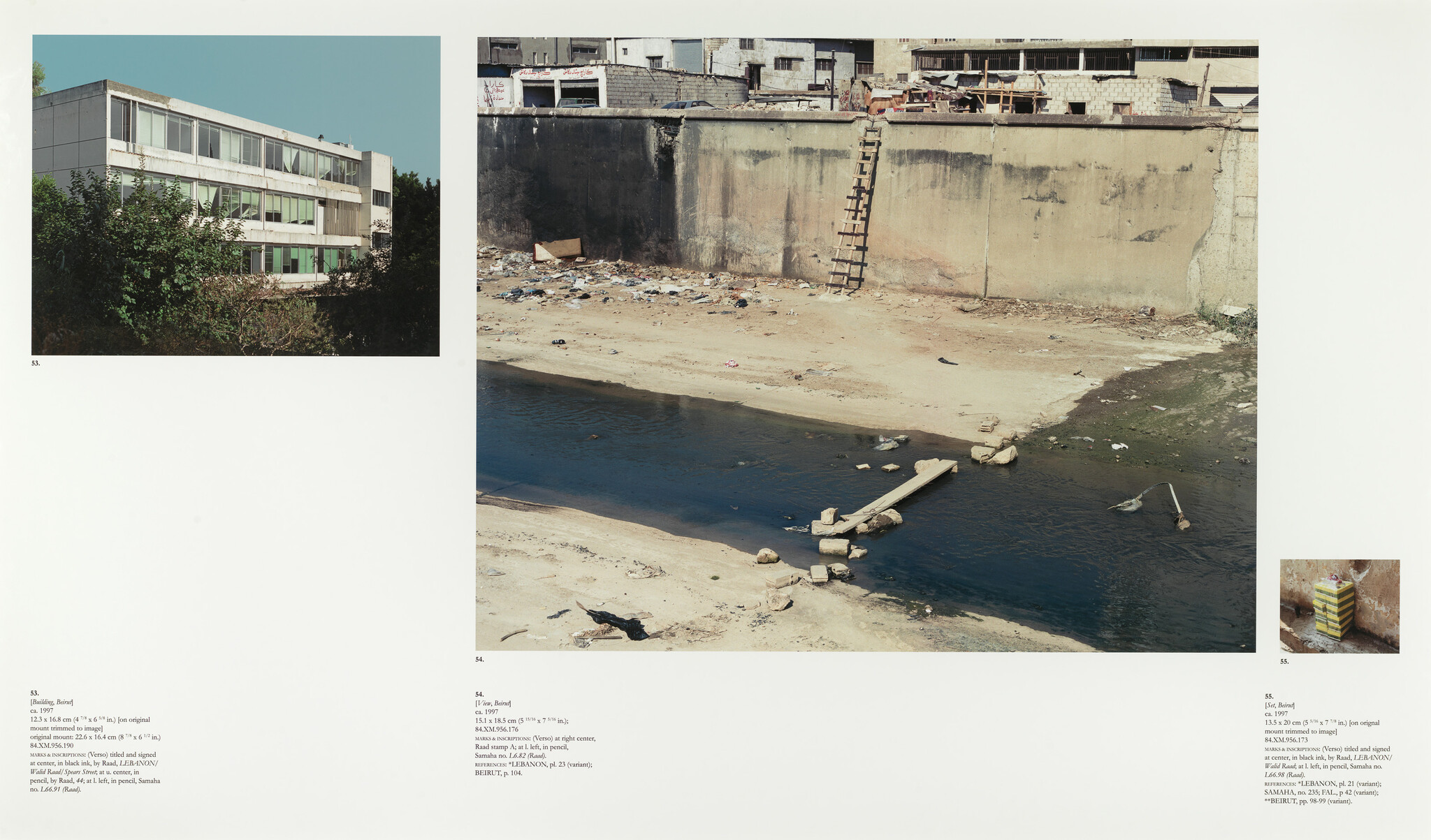 Dry riverbed with shallow polluted water, a plank crossing, and a ladder up a concrete wall.