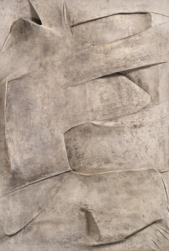 Large weathered stone relief with overlapping carved folds and smooth textured surfaces.