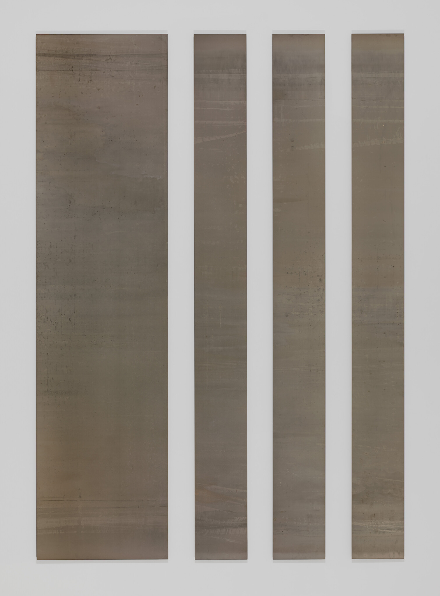 Four tall, narrow, vertical panels displayed side by side, each with a gradient of earthy tones ranging from dark at the top to lighter shades at the bottom, with subtle textures and markings throughout.