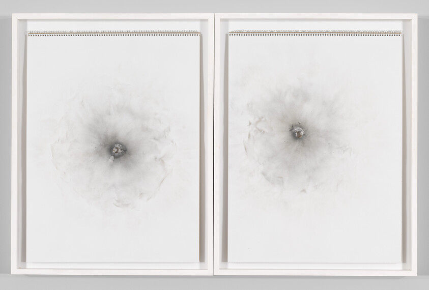 Two framed spiral-bound sketchpads show soft gray circular charcoal-like marks radiating from small central dark spots.