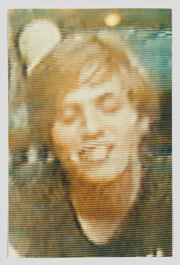 Young person with short hair smiling toward the camera in a grainy, pixelated image.