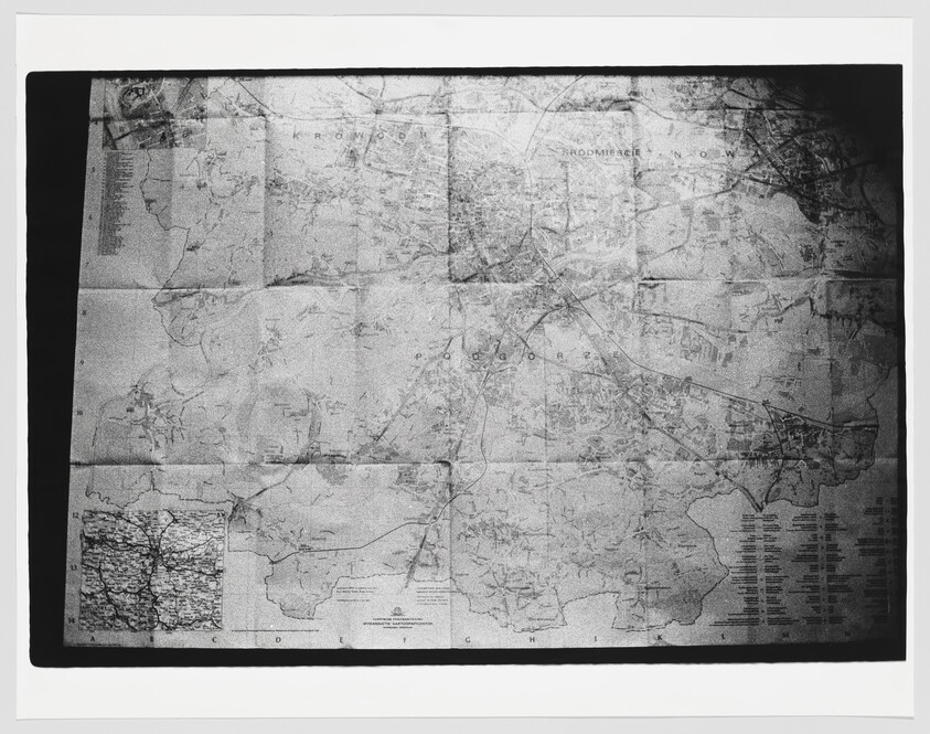 Folded paper map spread flat showing roads, towns, and an inset detail in the lower-left corner.