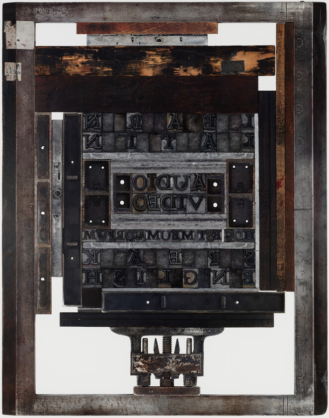 Rectangular metal printing press form with reversed type blocks, including inverted text reading "AUDIO VIDEO".