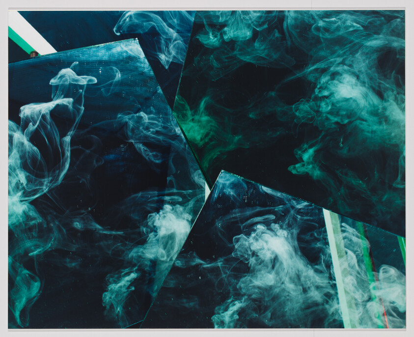 Dark reflective panels overlapped with swirling green-blue smoke creating an abstract, smoky composition.