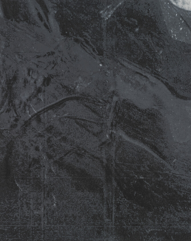 Dark crinkled plastic sheet stretched flat showing wrinkles, folds, and scattered dust and small debris.