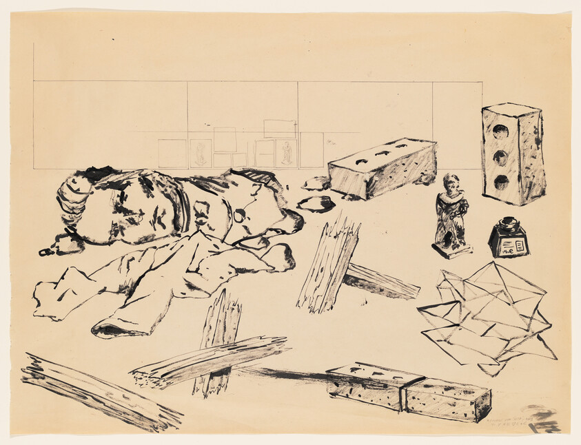 A cluttered tabletop with a broken doll, scattered wooden planks, bricks, a small statue, and crumpled paper.