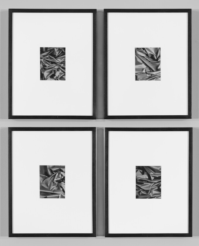 Four framed square artworks with small crumpled metallic pictures centered in large white mats.