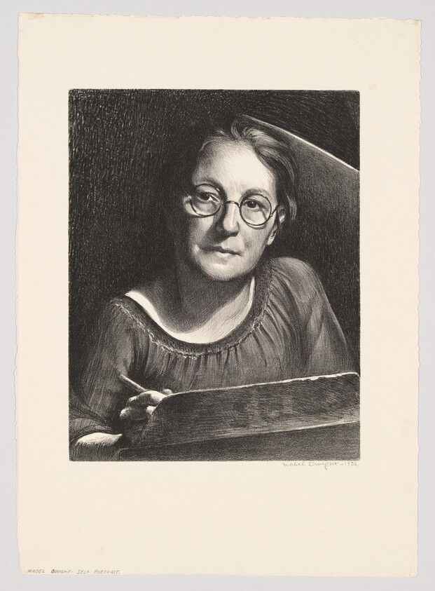 A woman with round glasses holding a pencil and looking thoughtfully over a sketchbook.