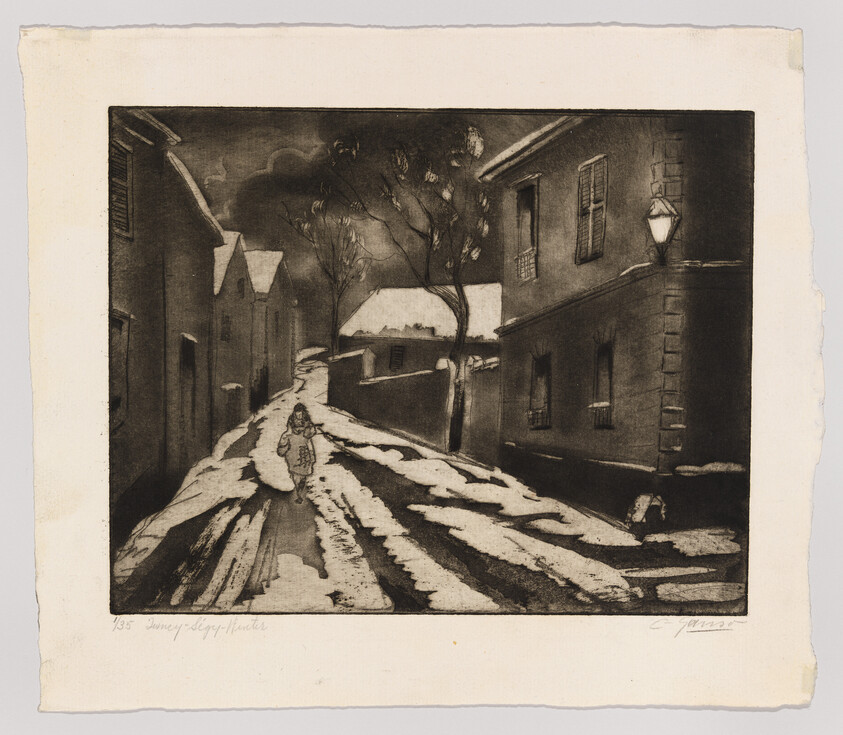 A lone person walks up a snow-lined village street at night under a lit streetlamp.