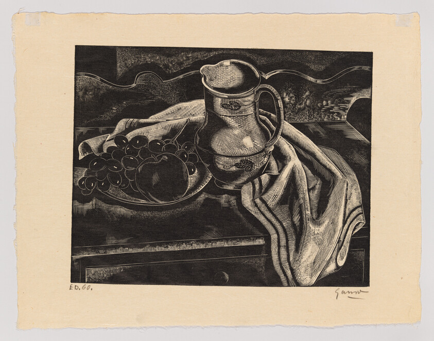 A ceramic pitcher sits beside a plate of fruit and a folded cloth on a wooden table.