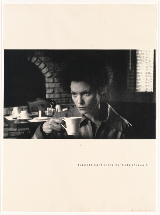 Woman sits in a diner holding a cup, looking intently toward something off-camera.