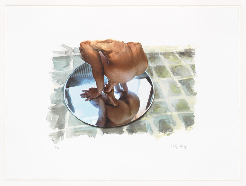 A crouching person peers into a round mirror on a tiled floor, revealing their reflection.