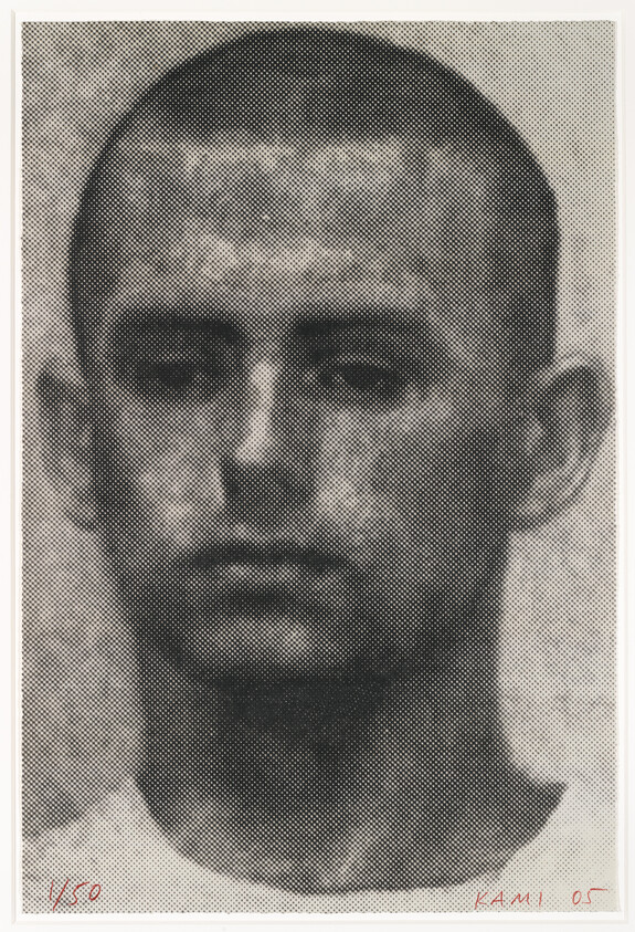 A close-up portrait of a young man with a shaved head and a neutral expression.