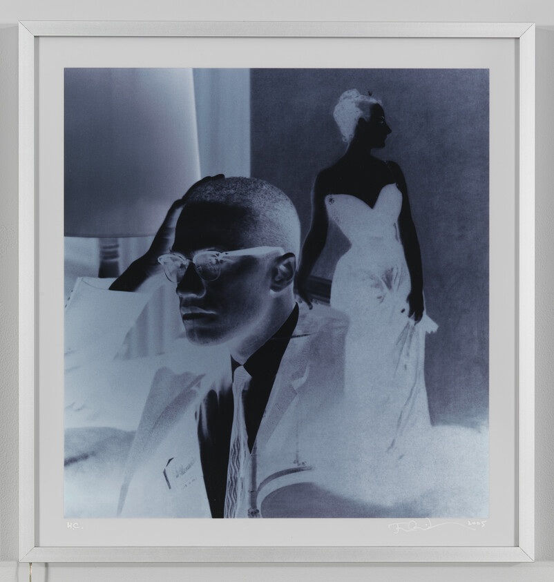 A framed negative-style portrait shows a man in glasses in the foreground and a woman in a gown behind him.