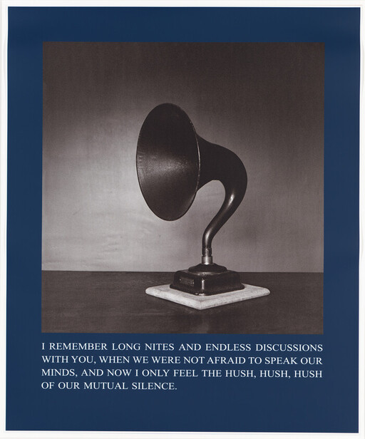 An antique gramophone horn on a base with a printed caption about mutual silence.