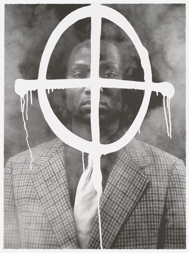 A monochrome image featuring a man in a houndstooth patterned suit and tie, with a serious expression. His face and upper body are overlaid with a white, dripping peace symbol, creating a stark contrast against the dark, smoky background.