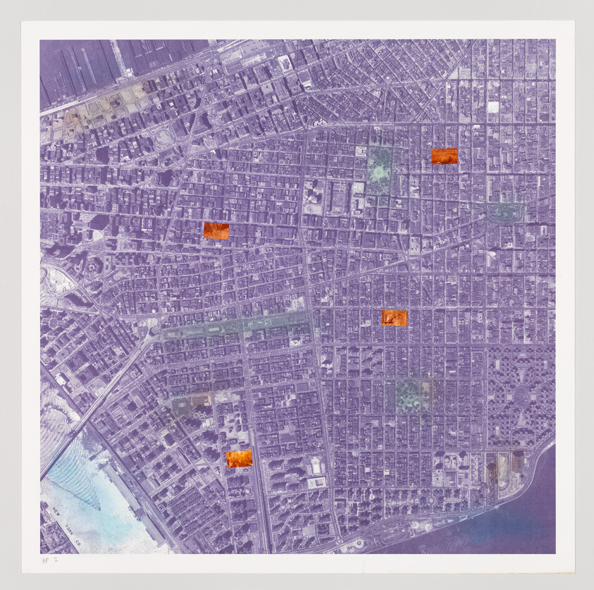 Aerial view of a dense urban grid with streets and buildings, depicted in a monochromatic purple hue with several bright orange rectangular marks scattered across the landscape. The image has a white border and is marked with "AP 2" in the bottom left corner.