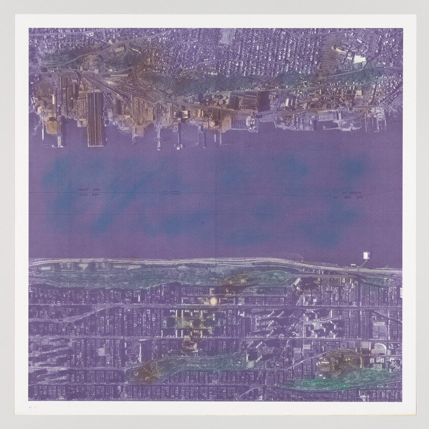 Aerial view of an urban area with a river running horizontally across the image, featuring a dense grid of streets and buildings, with color distortions that give the photograph a purple and blue hue.