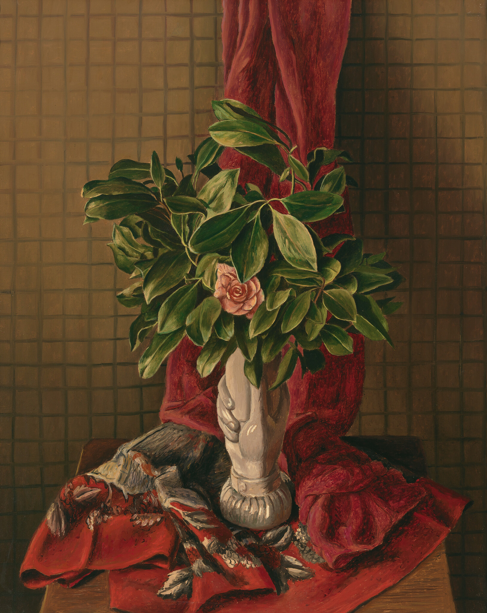 An ornate vase sits on draped red fabric, holding a full green plant with a single pink flower.